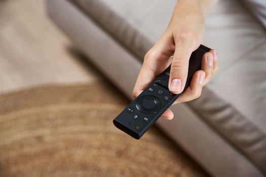 Woman switch TV set with remote control photo