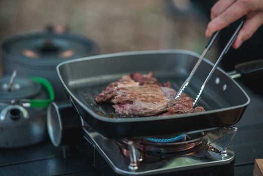 Young women enjoy to cooking meal on camping photo