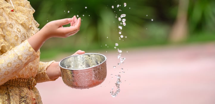 Female hands holding water bowl on Songkran festival photo
