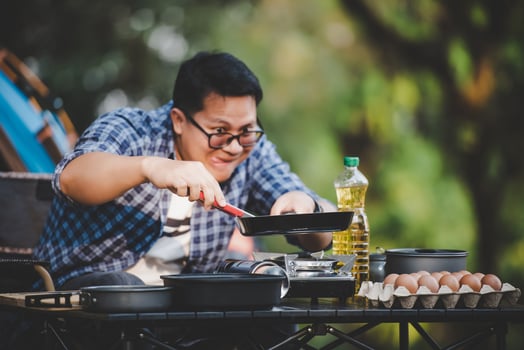 Portrait of Asian traveler man glasses pork steak frying photo