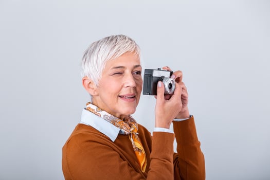 Mature female photographer taking pictures with old retro camera. Professional photographer doing a photoshoot. photo