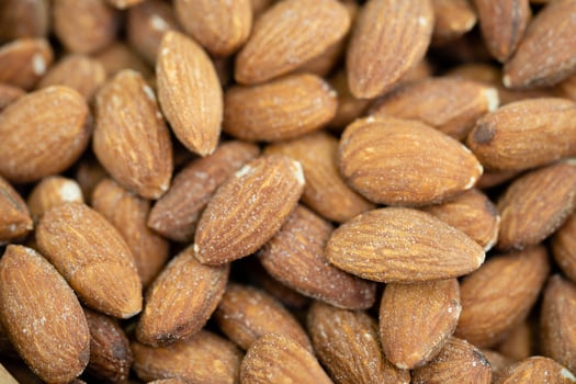 roasted and salted almonds on olive wood photo