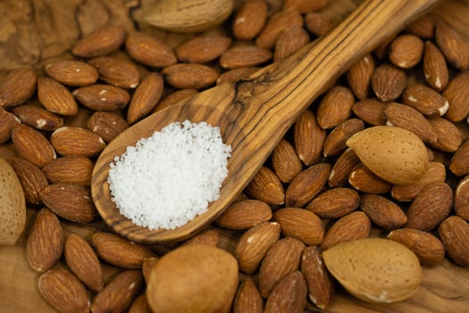 roasted and salted almonds on olive wood photo