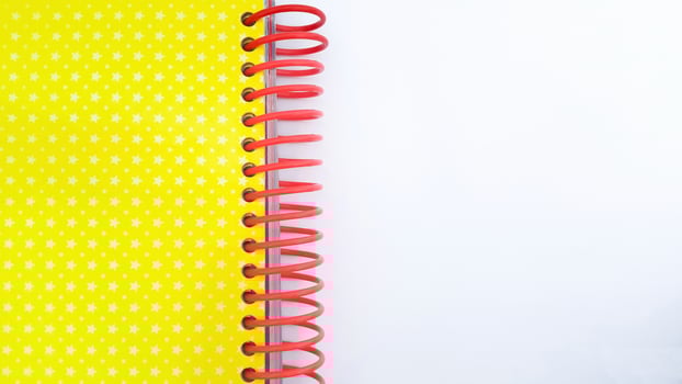 Close-up of red spiral bound notebook on white background photo