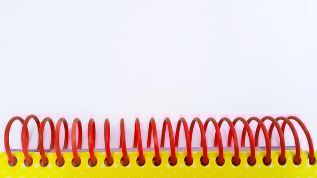 Close-up of red spiral bound notebook on white background photo