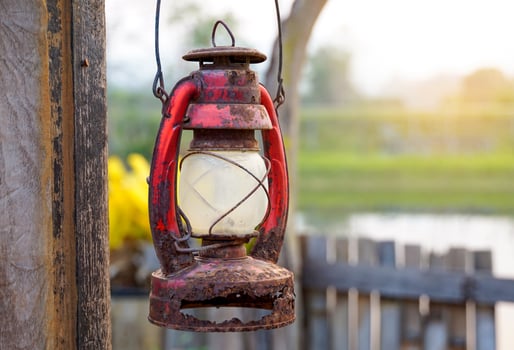 Antique oil lamp, old and decayed, used to hang a vintage garden decoration. Soft and selective focus. photo