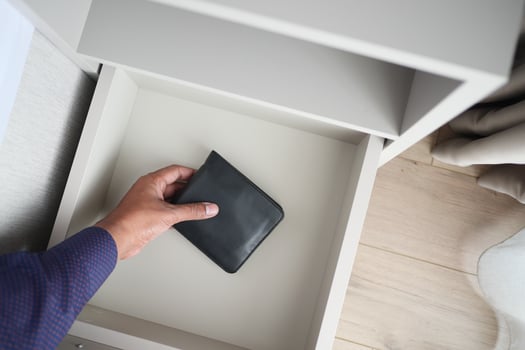 men stealing wallet from a drawer photo