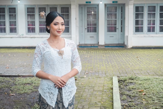 A young Indonesian woman with a happy successful expression wearing a white kebaya. Kartini's Day Concept. photo