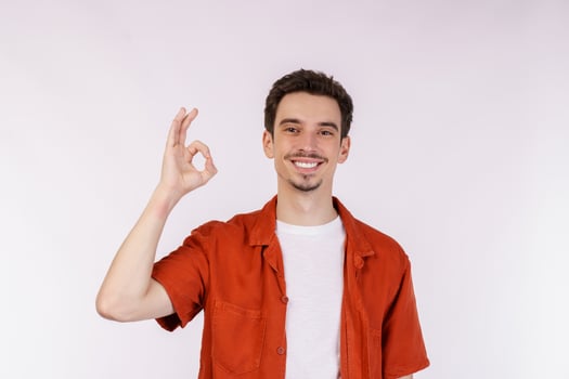 Portrait of young man pointing fingers at copy space isolated on white studio background photo