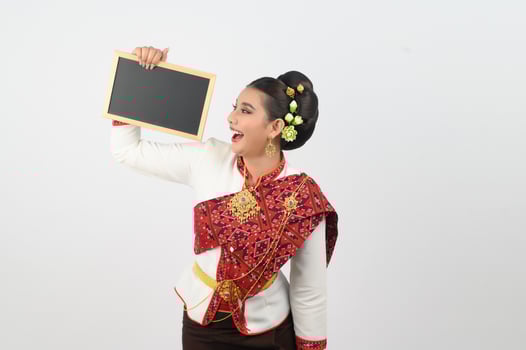 Portrait of Beautiful Thai Woman in Traditional Clothing Posing with blackboard photo