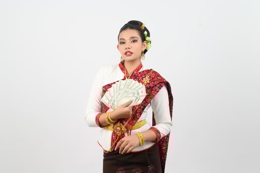Portrait of Beautiful Thai Woman in Traditional Clothing Posing with fan Banknote photo