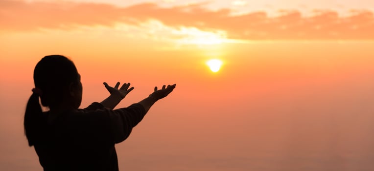 Silhouette of woman raising her hand praying spirituality and religion, banner and copy space of female worship to god. Christianity religion concept.Christians person are pray humility humble to god. photo