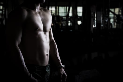 Sexy body of muscular young Asian man in gym. Concept of health care, exercise fitness, Strong muscle mass, body enhancement, fat reduction for men's health supplement product presentation. photo