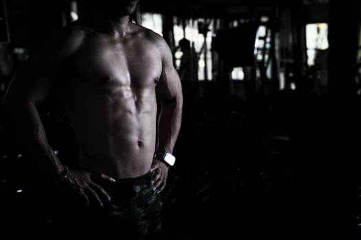 Sexy body of muscular young Asian man in gym. Concept of health care, exercise fitness, Strong muscle mass, body enhancement, fat reduction for men's health supplement product presentation. photo