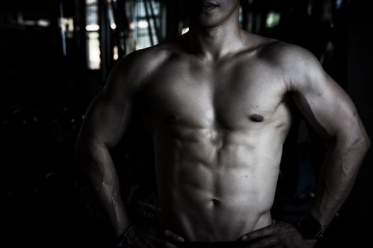 Sexy body of muscular young soldier Asian man in gym. Concept of health care, exercise fitness, Strong muscle mass, body enhancement, fat reduction for men's health supplement product presentation. photo