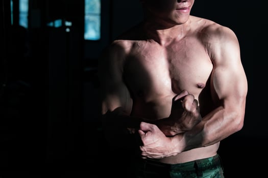 Sexy body of muscular young soldier Asian man in gym. Concept of health care, exercise fitness, Strong muscle mass, body enhancement, fat reduction for men's health supplement product presentation. photo