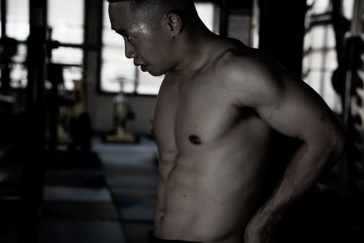 Sexy body of muscular young soldier Asian man in gym. Concept of health care, exercise fitness, Strong muscle mass, body enhancement, fat reduction for men's health supplement product presentation. photo