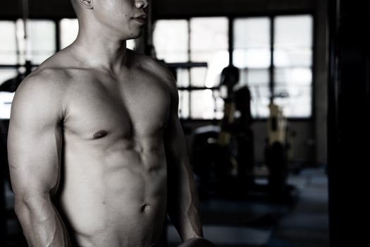Sexy body of muscular young soldier Asian man in gym. Concept of health care, exercise fitness, Strong muscle mass, body enhancement, fat reduction for men's health supplement product presentation. photo