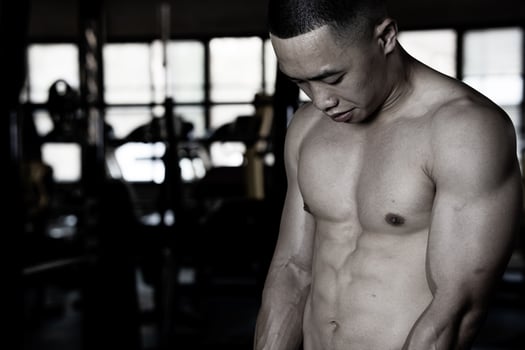 Sexy body of muscular young soldier Asian man in gym. Concept of health care, exercise fitness, Strong muscle mass, body enhancement, fat reduction for men's health supplement product presentation. photo