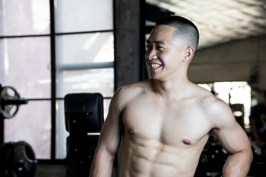 Sexy body of muscular young soldier Asian man in gym. Concept of health care, exercise fitness, Strong muscle mass, body enhancement, fat reduction for men's health supplement product presentation. photo