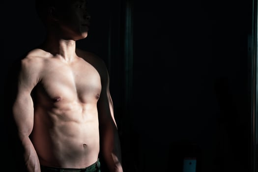 Sexy body of muscular young soldier Asian man in gym. Concept of health care, exercise fitness, Strong muscle mass, body enhancement, fat reduction for men's health supplement product presentation. photo