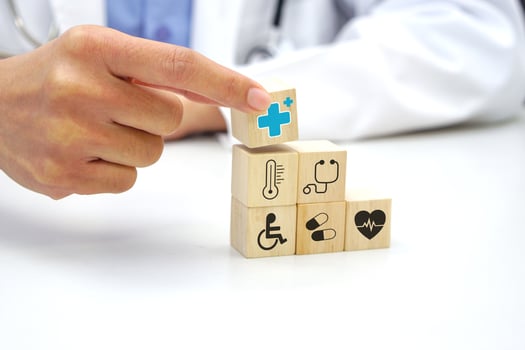 Hand holding a wooden block cube with healthcare medical icon symbol. Medical and health concept. photo