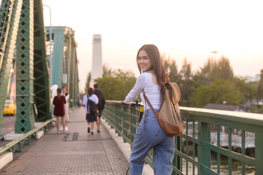 Portrait of young beautiful woman with an electric scooter  over bridge in modern city  background photo