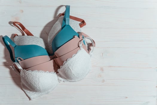 Set of colorful bra on wooden background, closeup. photo