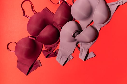 Set of colorful bra on red background, closeup. photo