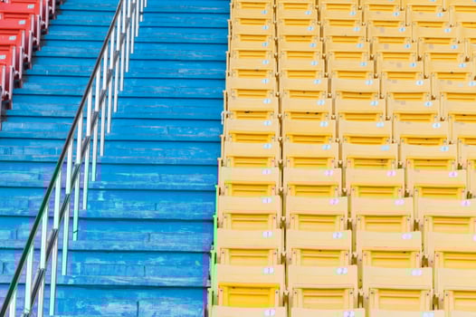Empty orange and yellow seats at stadium,Rows of seat on a soccer stadium photo