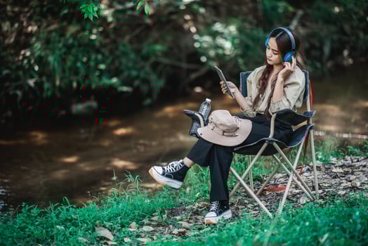 Young asian woman sitting on chair listening music from headphone photo