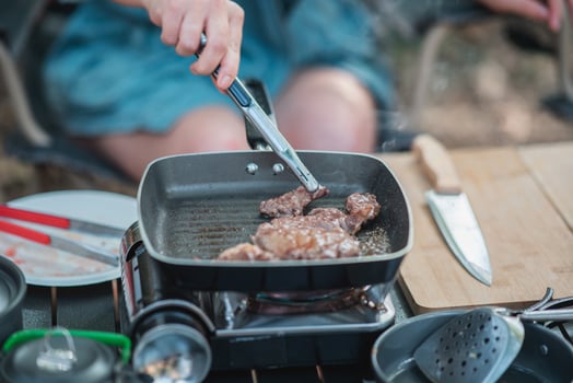 Young women enjoy to cooking meal on camping photo