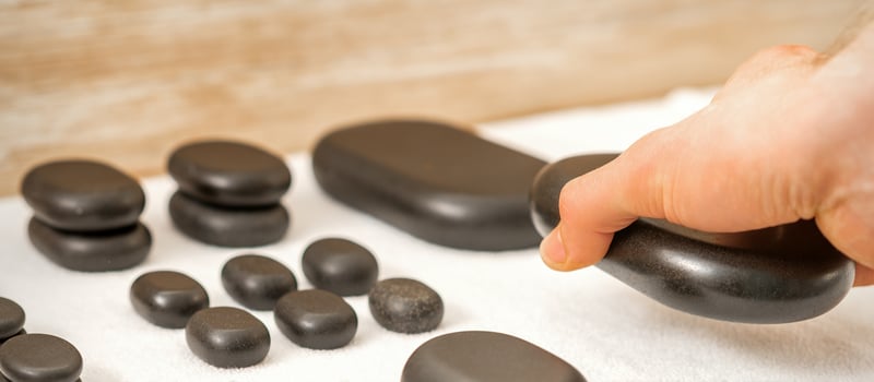 Masseur lays out massage stones photo