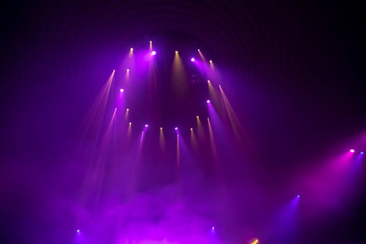 Purple rays from stage spotlights on a dark background. photo