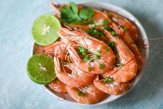 shrimp on white bolw and wooden background dining table food, Fresh shrimps prawns seafood lemon lime with herbs and spice, top view photo