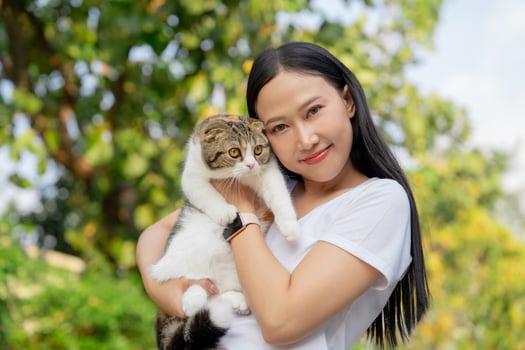 Asian woman holding a cat at the park photo