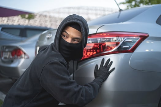 robber in black mask with car. robbery and crime concept. car theft concept. photo