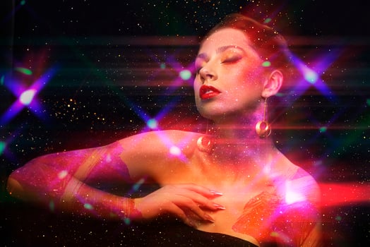 Glamorous girl with art make-up in the rays of light glitter dances with her eyes closed. Night club beautiful model. photo