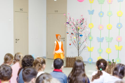 young actress in a fox costume speaking in front of children photo
