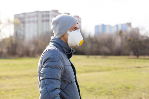 A man wearing a mask on the street. Protection against virus and grip photo