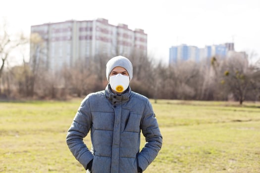 Young man wearing a face mask to protect against flu or infections photo