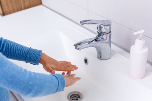 Small child washing hands with soap and water, detail photo