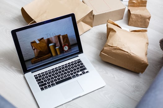 Online shopping  ecommerce and delivery service concept  Paper cartons with a shopping cart or trolley logo on a laptop keyboard, photo