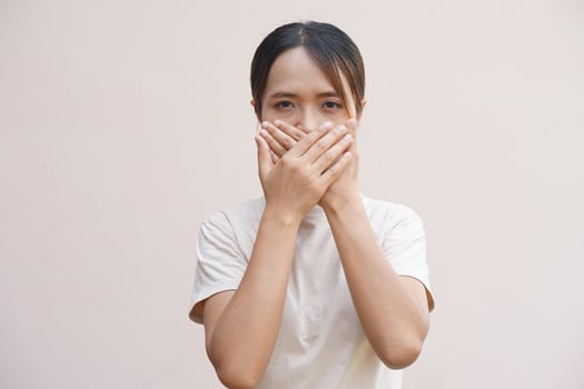 Asian woman covering her mouth with her hands photo