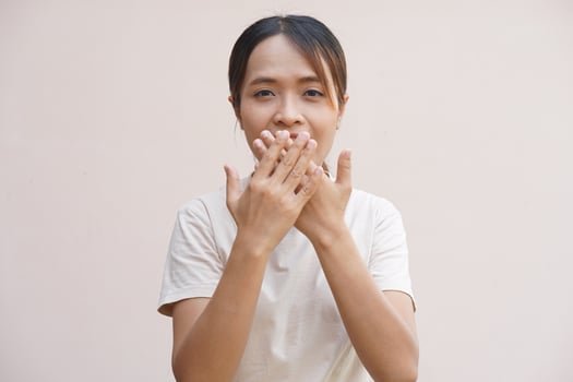 Asian woman covering her mouth with her hands photo