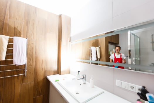 A man cleaning a shower glass photo