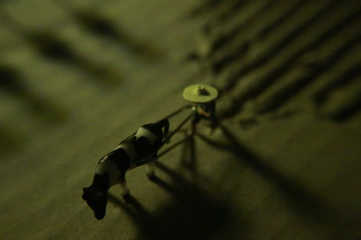 miniature figure of a farmer plowing a field with his cow on a cardboard. photo