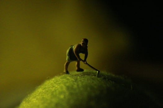 miniature figure of a female farmer working the land with a sunrise background. photo