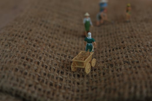 miniature figures of farmers working on gunny sacks. concept of agriculture photo. photo