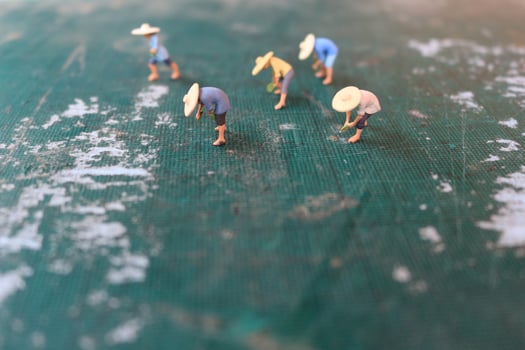miniature figures of farmers working on a cutting mat. concept of agriculture photo. photo